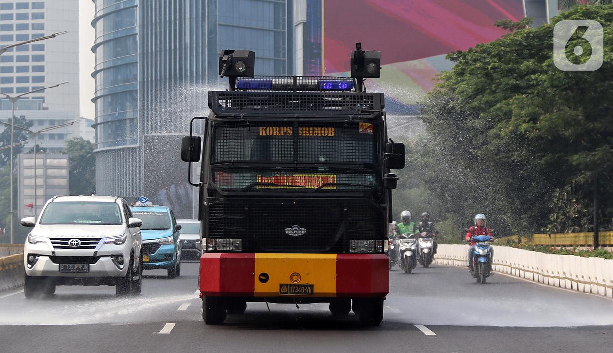 Puluhan personel serta kendaraan dinas operasional gabungan Pemprov DKI Jakarta dan Polda Metro Jaya melakukan penyiraman di kedua sisi sepanjang Jalan Sudirman-Thamrin. (Liputan6.com/Angga Yuniar)