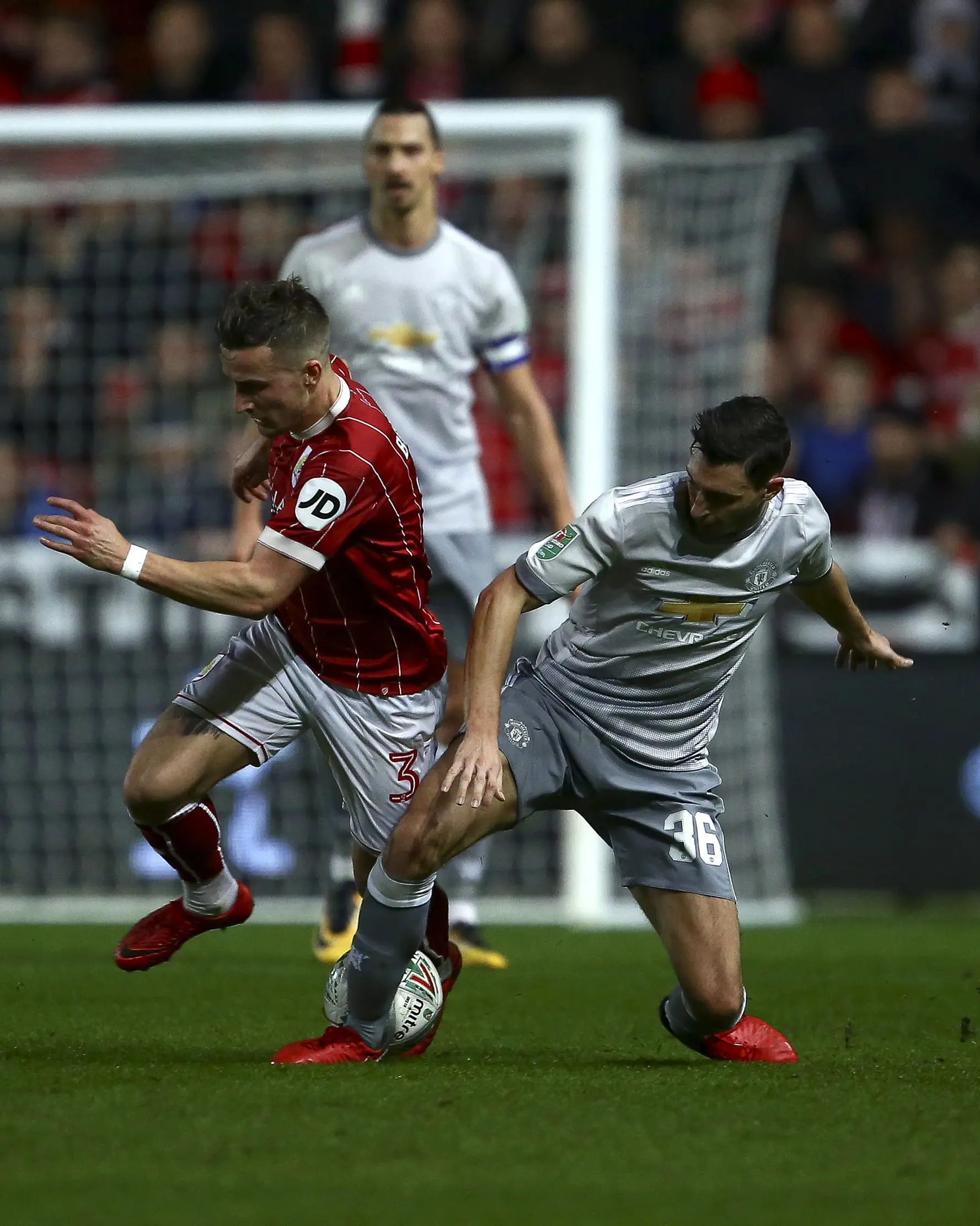 Pemain Bristol City, Joe Bryan berebut bola dengan pemain Manchester United, Matteo Darmian. (Geoff CADDICK / AFP)