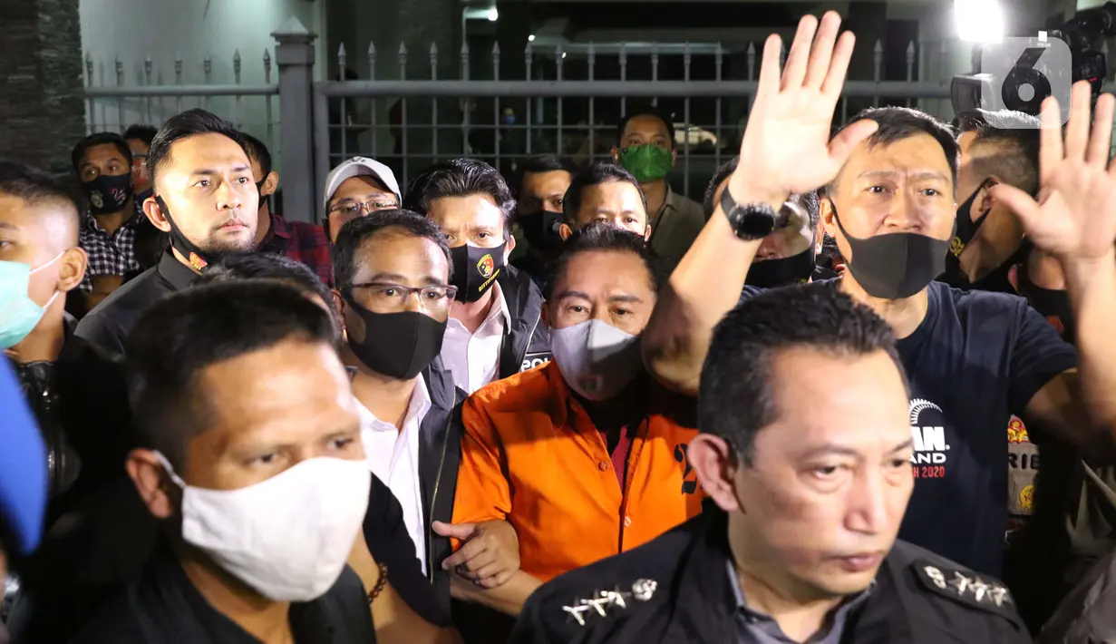 Terpidana pengalihan hak tagih atau cessie Bank Bali, Djoko Sugiarto Tjandra (rompi oranye) dikawal petugas usai tiba di Bandara Halim Perdanakusuma Jakarta, Kamis (30/7/2020). Djoko Tjandra tiba sekitar pukul 22.30 WIB dan langsung dibawa ke Bareskrim Mabes Polri. (Liputan6.com/Helmi Fithriansyah)