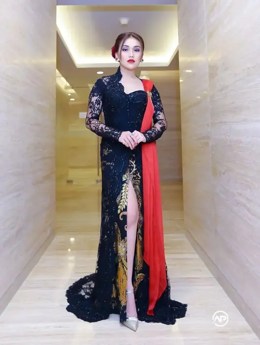 Kebaya hitam berpayet dengan selendang merah pun membuat Ayu tampak anggun. Ditambah kain batik model slit yang membuatnya tampak jenjang.  [@ayutingting92]