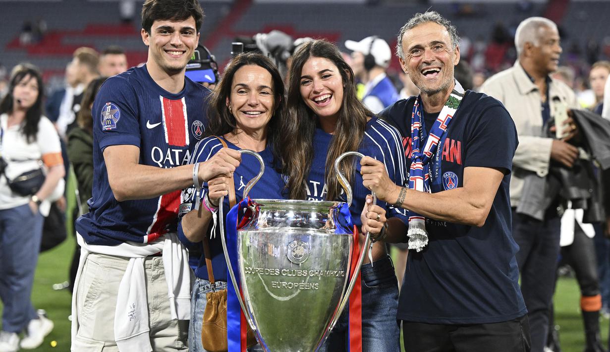 Pelatih PSG, Luis Enrique berfoto bersama dengan istri beserta anak-anaknya sambil memegang trofi Liga Champions 2024/2025 setelah berhasil mengalahkan Inter Milan dalam laga final yang berlangsung di Allianz Arena, Munchen, Jerman, Minggu (01/06/2025) dini hari WIB. (AP Photo/DPA/Sven Hoppe)
