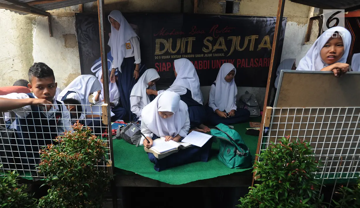 Siswa kelas 8 SMP 1 Cijeruk Terbuka belajar di halaman rumah warga di Kampung Cijeruk RT 002/005, Desa Palasari, Kabupaten Bogor, Jawa Barat, Senin (2/9/2019). Mereka tidak memiliki bangunan sekolah sejak tahun 2011. (merdeka.com/Arie Basuki)