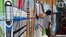 Pekerja menyelesaikan pembuatan mural Kota Jakarta di Tanah Kusir, Kebayoran Lama, Jakarta, Jumat (26/11/2021). Mural tersebut bertemakan Kota Jakarta dengan gambar ikon seperti ondel-ondel, Monas hingga transportasi. (Liputan6.com/Herman Zakharia)