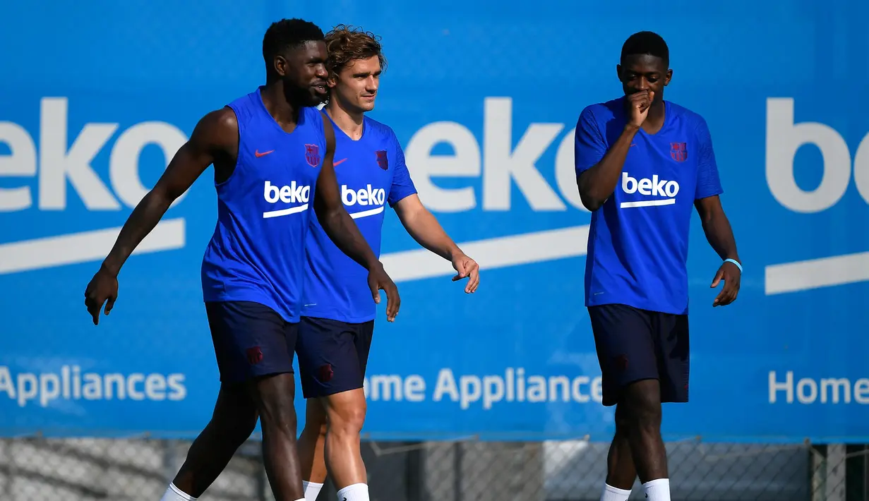 Penyerang baru Barcelona, Antoine Griezmann bersama rekannya Samuel Umtiti dan Ousmane Dembele tiba untuk mengikuti latihan pramusim pertama di Joan Gamper, Barcelona (15/7/2019). Barcelona akan menghadapi Chelsea pada pertandingan pramusim. (AFP Photo/Lluis Gene)