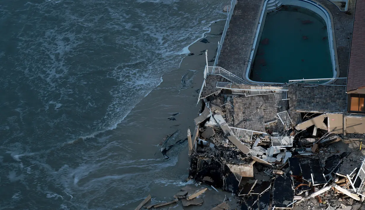 Pemandangan dari lantai 18 sebuah gedung kondominium menunjukkan sebuah bangunan kondominium yang rusak setelah Badai Nicole mendarat di Daytona Beach, Florida (10/11/2022). Badai Nicoler datang ke darat sebagai badai Kategori 1 sebelum melemah menjadi badai tropis saat bergerak melintasi negara bagian. (Joe Raedle/Getty Images/AFP)