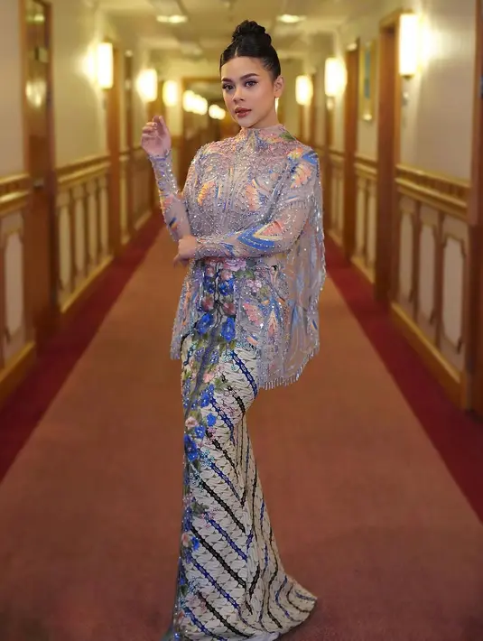 Bagian atas dress tersebut hadir dengan siluet kebaya. Sementara bagian roknya hadir berupa batik motif parang warna cokelat-beige.