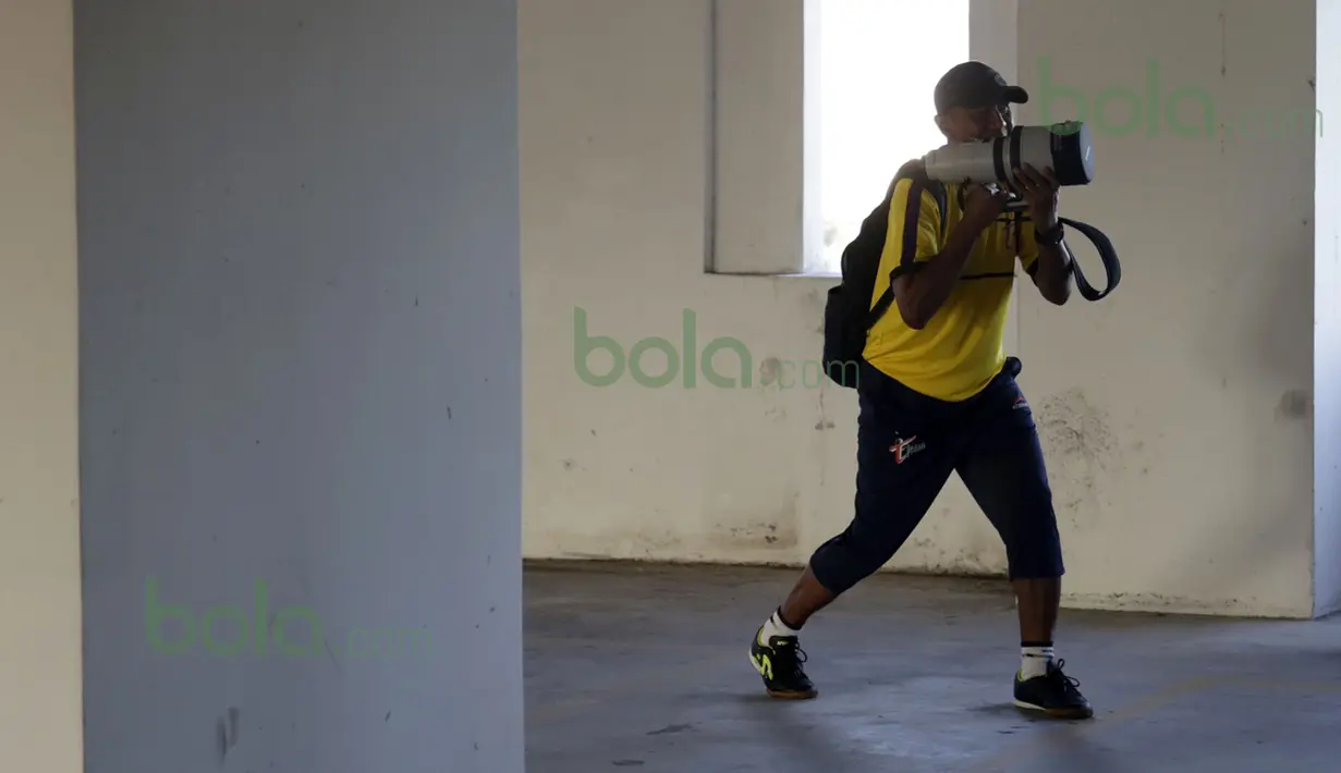 Pelatih T-Team, Rahmad Darmawan memegang lensa tele milik Bola.com seperti layaknya senjata bazoka dan mengarahkannya ke pemain saat berlatih di parkiran mobil Hotel Tower Regency di Ipoh, Perak, Malaysia, Sabtu (30/01/2016). (Bola.com/Nicklas Hanoatubun)