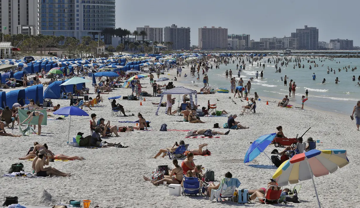 Pengunjung menikmati Clearwater Beach di Florida, Amerika Serikat, Rabu (18/3/2020). Para pengunjung diminta menjaga jarak satu sama lain untuk mengurangi risiko penyebaran virus corona COVID-19. (AP Photo/Chris O'Meara)
