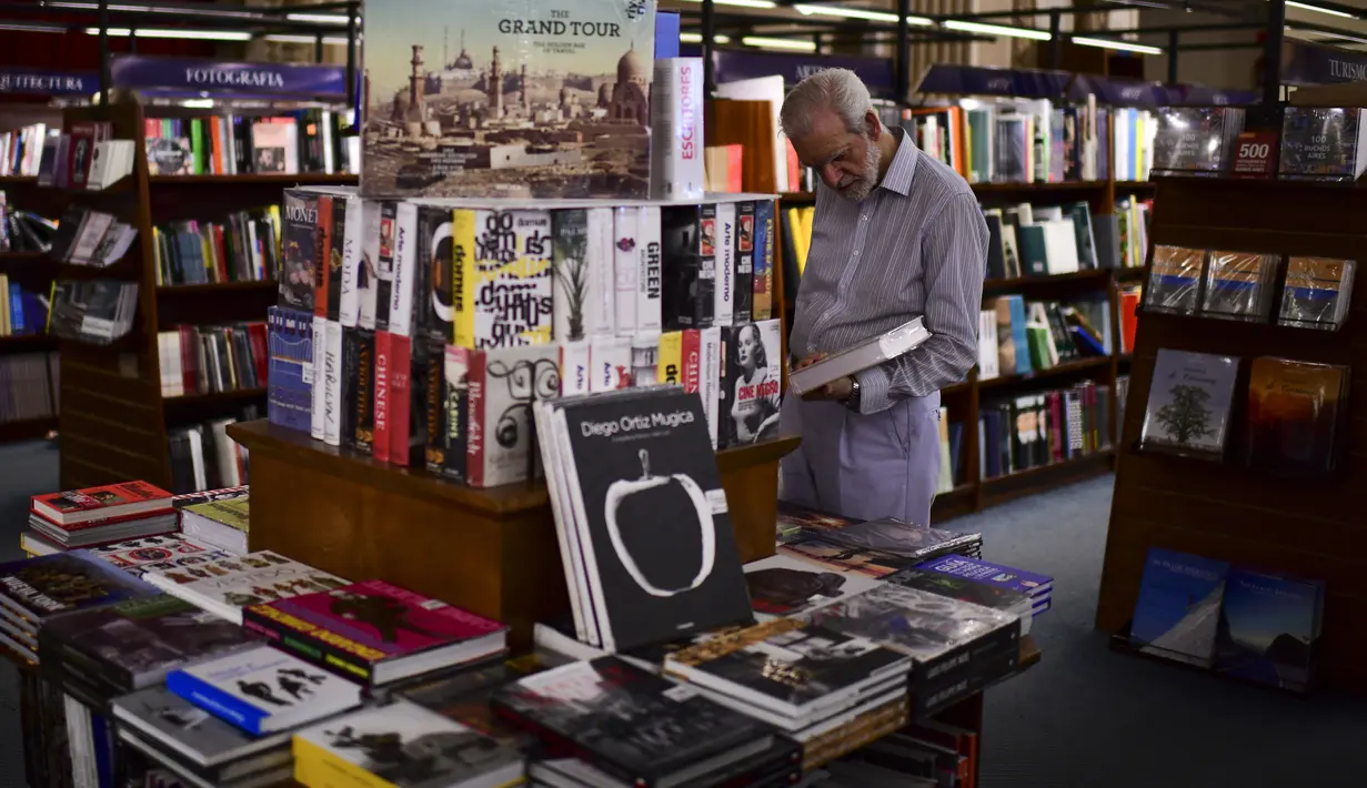 Seorang pria melihat buku di toko buku "El Ateneo Grand Splendid" di Buenos Aires, Argentina pada Rabu (9/1). El Ateneo Grand Splendid adalah bangunan yang besar dan megah bekas gedung teater pada awal abad ke-20. (RONALDO SCHEMIDT / AFP)