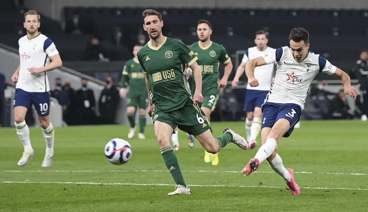 Gelandang Tottenham Hotspur, Sergio Reguilon menembak bola saat bertanding melawan Sheffield United pada pertandingan Liga Inggris di Stadion Tottenham Hotspur di London, Senin (3/5/2021).Tottenham menang telak atas Sheffield United 4-0. (Shaun Botterill/Pool via AP)