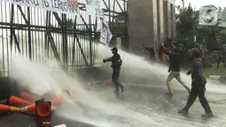 Aparat kepolisian melepaskan water canon untuk membubarkan massa aksi demo mahasiswa di depan Gedung DPR, Jakarta, Senin (11/4/2022). Mahasiswa yang tergabung dalam aliansi BEM SI menggelar unjuk rasa besar-besaran di depan Gedung DPR/MPR RI, Senin ini. (Liputan6.com/Angga Yuniar)