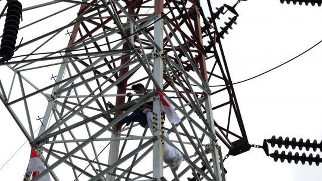 Pria berpakaian pocong di atas tower SUTET