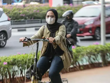 Warga melintas memakai masker untuk melindungi diri dari debu di Jalan Sudirman,Jakarta, Selasa (15/8/2023). (Liputan6.com/Faizal Fanani)