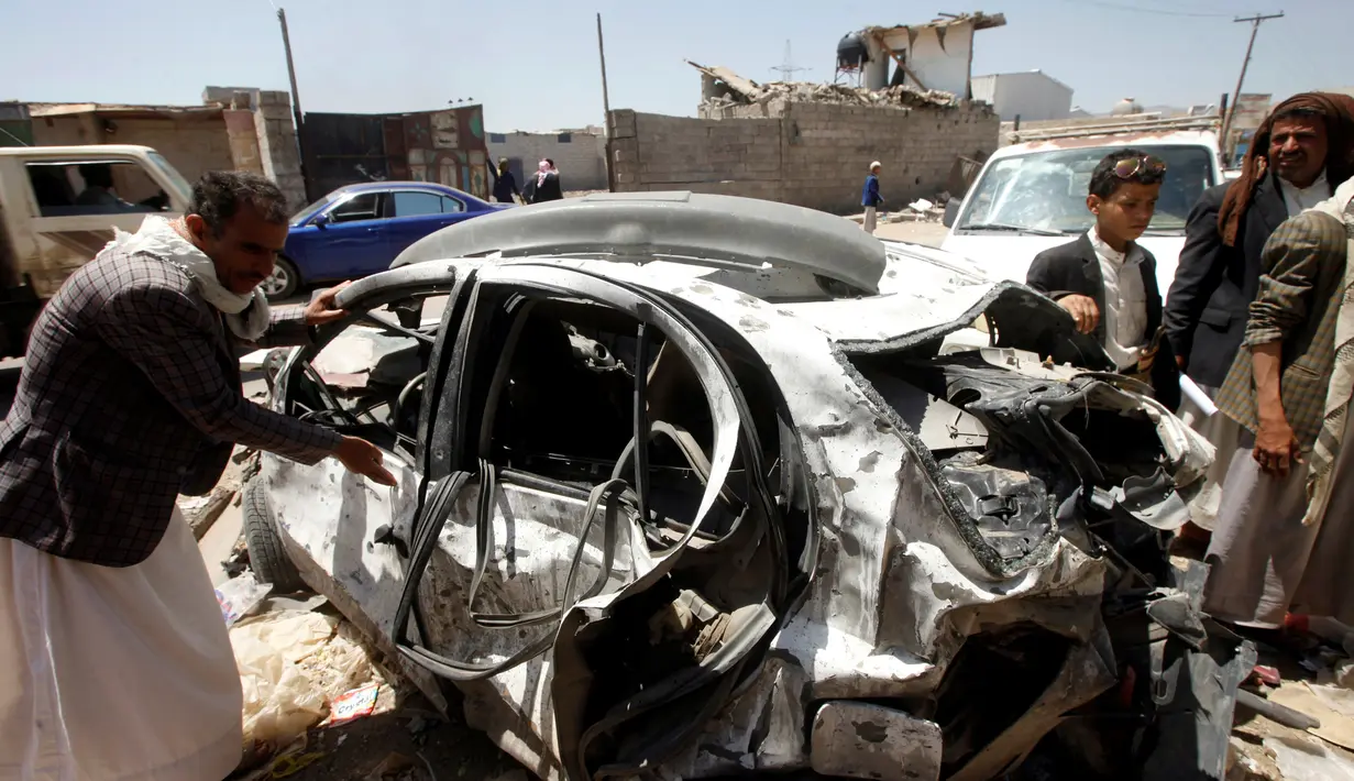 Warga memeriksa sebuah mobil yang hancur akibat serangan udara yang dipimpin koalisi militer Saudi di Kota Sanaa, Yaman, (4/9). Serangan udara Saudi tersebut banyak  menewaskan warga sipil yang tak berdosa. (REUTERS/Mohamed al-Sayaghi)