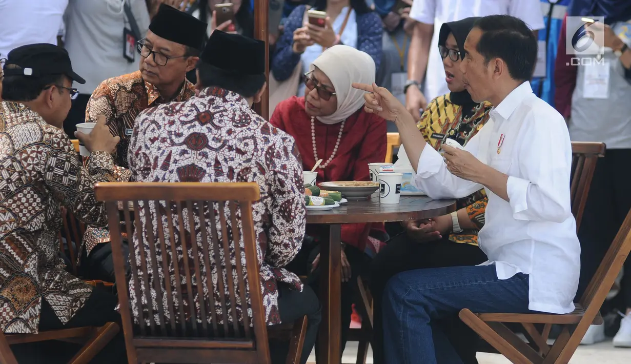 Presiden Joko Widodo (Jokowi) berbincang sambil menjajal makanan saat meninjau Rest Area 538 seusai meresmikan ruas  Tol Sragen-Ngawi, Jawa Tengah, Rabu (28/11). Jokowi duduk semeja dengan kepala serta pimpinan daerah setempat. (Liputan6.com/Angga Yuniar)