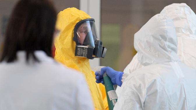 Presiden Rusia, Vladimir Putin dengan alat pelindung diri lengkap mengunjungi rumah sakit tempat pasien positif corona dirawat di Kommunarka, Moskow, Selasa (24/3/2020). Putin memberikan apresiasi kepada para dokter dan tenaga medis dalam menangani pasien COVID-19. (Alexey DRUZHININ/SPUTNIK/AFP)