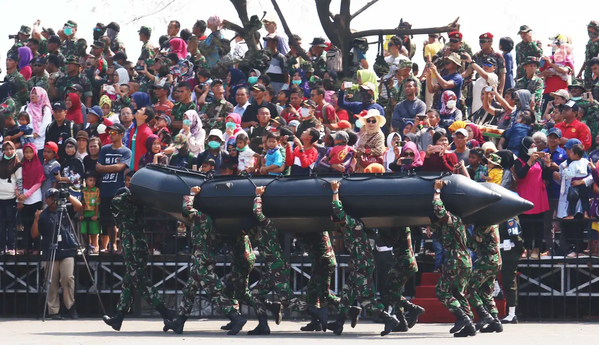Masyarakat melihat antraksi prajurit TNI menggotong perahu karet saat geladi resik HUT TNI ke-72 di Cilegon, Banten, Selasa (3/10). Geladi resik tersebut untuk memperingati HUT TNI ke-72 yang dilaksanakan tanggal 5 Oktober. (Liputan6.com/Angga Yuniar)