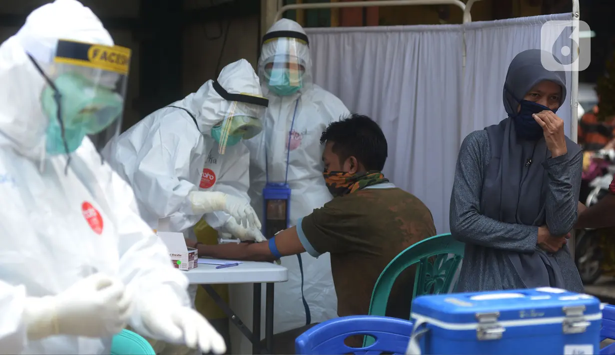 Petugas medis melakukan Rapid Test dan Swab Test Covid-19 kepada para pedagang dan pemilik kios pasar Perumnas Klender, Jakarta, Jumat (29/5/2020). (merdeka.com/Imam Buhori)