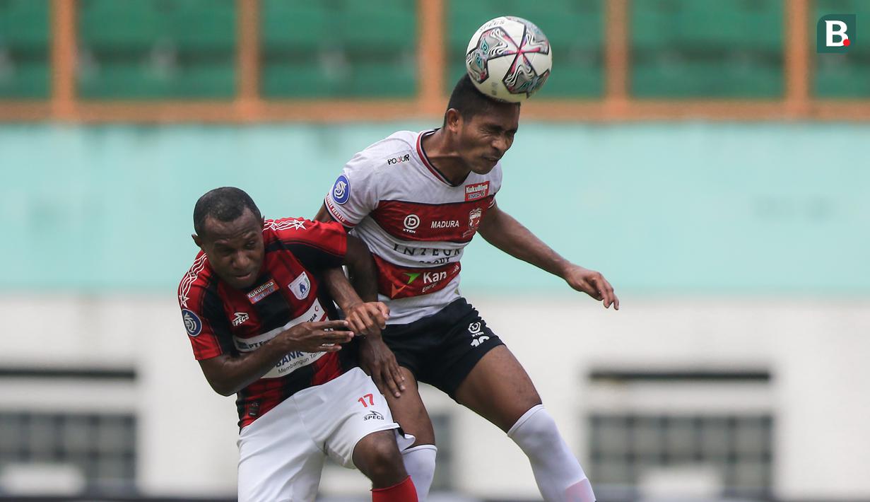 Pemain Madura United, Dodi Alekvan Djin (kanan) dan pemain Persipura Jayapura, Yohanes Pahabol berduel udara dalam laga pekan ke-6 BRI Liga 1 2021/2022 di Stadion Wibawa Mukti, Cikarang, Minggu (03/10/2021). (Bola.com/Bagaskara Lazuardi)