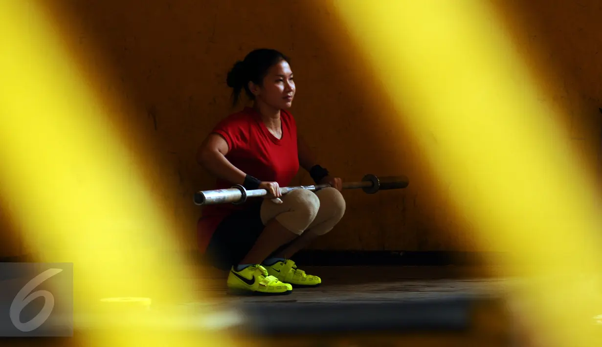 Salah satu atlet angkat besi putri Indonesia bersiap melakukan latihan di luar gedung PB PABBSI, Stadion GBK Jakarta, Senin (11/1/2016). Latihan dilakukan diluar gedung akibat proses renovasi gedung PB PABBSI. (Liputan6.com/Helmi Fithriansyah)