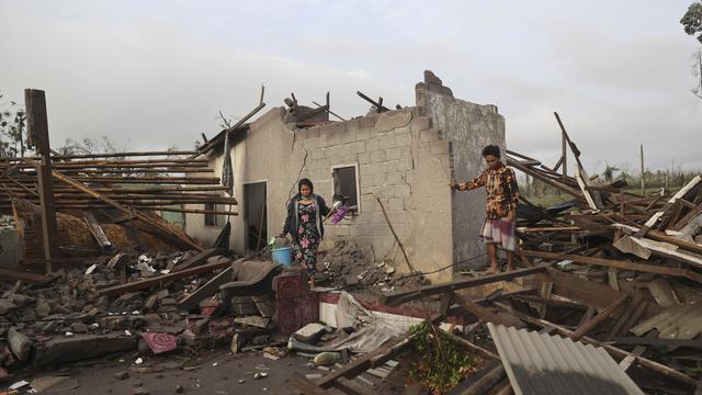 <span>Warga memeriksa rumah yang rusak akibat erupsi Gunung Semeru di kawasan Lumajang, Jawa Timur, Minggu (5/12/2021). Gunung Semeru memuntahkan kolom tebal abu, gas yang membakar dan lava menuruni lerengnya dalam letusan tiba-tiba yang dipicu oleh hujan lebat. (AP Photo/Trisnadi)</span>