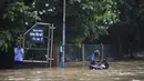 Pengendara motor  berdiri di jalan yang tergenang air setelah hujan monsun di Gurgaon di pinggiran New Delhi (19/8/2020). Jumlah korban dari banjir tahunan di seluruh Asia Selatan naik menjadi hampir 1.300. (AFP/Xavier Galiana)