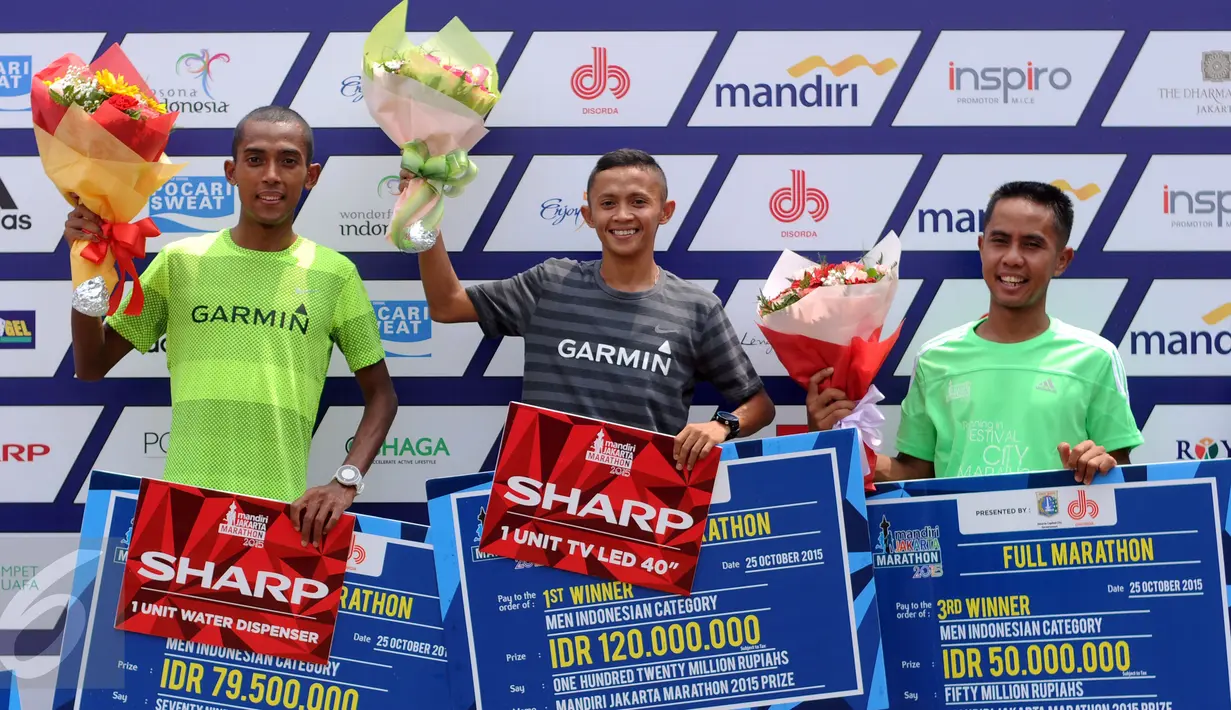 Pelari Indonesia, Asmara Bara (tengah) mengangkat tangan usa imenerima hadiah lombalari Jakarta Marathon 2015 di Silang Monas Jakarta, Minggu (25/10/2015). Bara mencatat waktu dua jam 32 menit. (Liputan6.com/Helmi Fithriansyah)