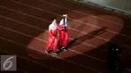 Liliyana Natsir (kiri) dan Tontowi Ahmad berlari membawa obor api PON XIX Jabar saat upacara pembukaan di Stadion Gelora Bandung Lautan Api, Bandung, Sabtu (17/9). PON XIX Jabar berlangsung hingga 29 September. (Liputan6.com/Helmi Fithriansyah)