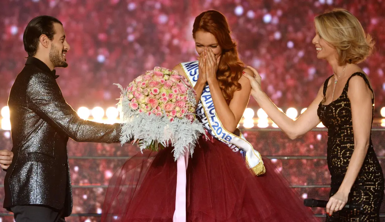 Maeva Coucke (tengah) menerima bunga dari juri setelah dinobatkan sebagai Miss France 2018 di Chateauroux, Prancis tengah (16/12). Coucke  merupakan wanita ketiga dari Nord-Pas-de-Calais untuk memenangkan gelar tersebut. (AFP Photo/Guillaume Souvant)