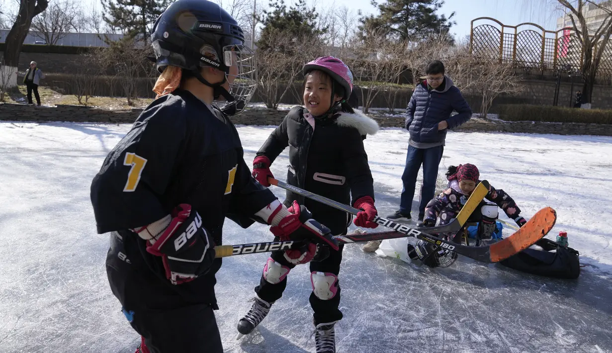 Anak-anak bermain hoki es di kanal beku saat Olimpiade Musim Dingin 2022 hampir berakhir di Beijing pada Sabtu, 19 Februari 2022. (AP Photo/Ng Han Guan)