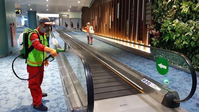 Pengelola Bandara Internasional Soekarno Hatta, PT Angkasa Pura II (AP II), menyemprotkan cairan disinfektan di  Terminal 2 dan Terminal 3 Kedatangan Internasional, Kamis (5/3/2020) dini hari.