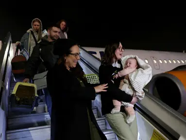 Pengungsi Yahudi Ukraina dan imigran baru yang melarikan diri dari perang di negara mereka turun dari pesawat setibanya di Bandara Ben Gurion, Tel Aviv, Israel, 22 Desember 2022. Sebanyak 100 orang Yahudi Ukraina tiba di Israel, termasuk beberapa penumpang yang terbaring di tempat tidur dan dalam kondisi sakit. (GIL COHEN-MAGEN/AFP)