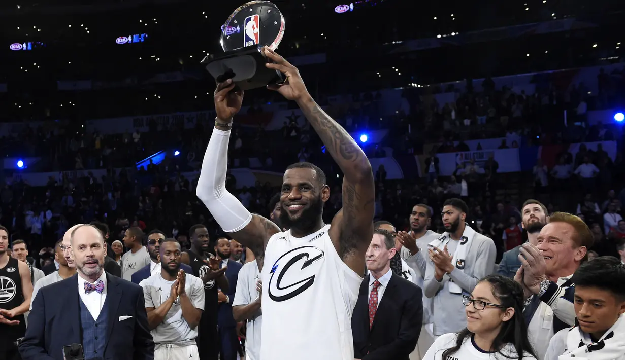 LeBron James mengangkat trofi MVP usai timnya menang pada laga NBA All-Star basketball game di Los Angeles, (18/2/2018). Tim LeBron menang 148-145. (AP/Chris Pizzello)