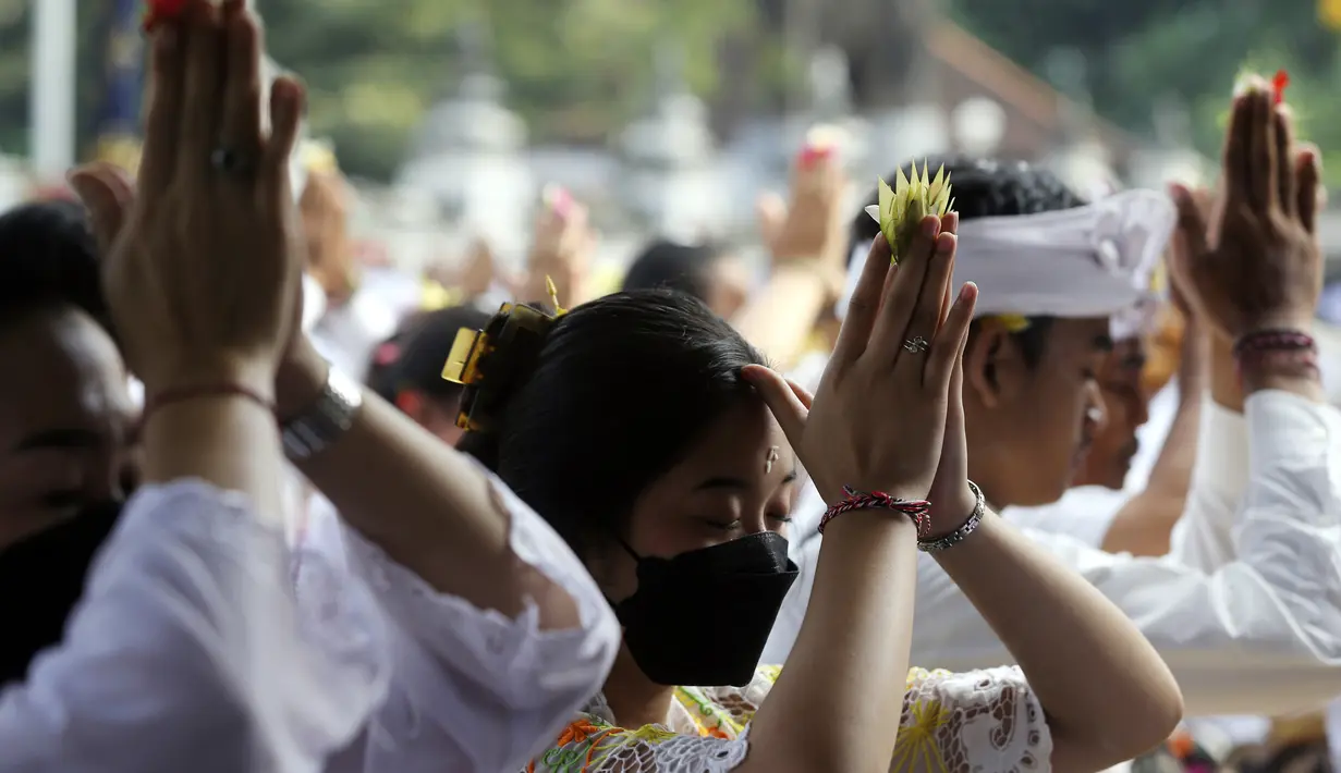 Umat Hindu Bali berdoa saat merayakan Hari Raya Kuningan di Pura Sakenan, Bali, Sabtu (18/6/2022). Kuningan menandai hari terakhir perayaan Galungan, salah satu upacara keagamaan terbesar umat Hindu di Bali. (AP Photo/Firdia Lisnawati)