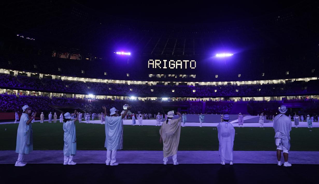 Para penampil melambai saat para atlet meninggalkan lapangan setelah upacara penutupan Olimpiade Musim Panas 2020, Minggu, 8 Agustus 2021, di Tokyo, Jepang. (AP/Jae C.Hong)