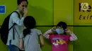 Seorang anak mengenakan masker saat berada di Stasiun Gambir, Jakarta Pusat, Jumat (31/01). Dalam rangka pencegahan Virus Corona, PT Kereta Api Indonesia (persero) melakukan sosialisasi kepada penumpang dengan membagi-bagikan masker di stasiun Gambir. (merdeka.com/Imam Buhori)