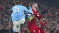 Pemain Manchester City, Jeremy Doku, melepaskan tendangan ke arah pemain Liverpool, Alexis Mac Allister, ketika kedua tim bertemu pada pekan ke-28 Premier League 2023/2024 di Anfield, Minggu (10/3/2024) malam WIB. (AP Photo/Jon Super)