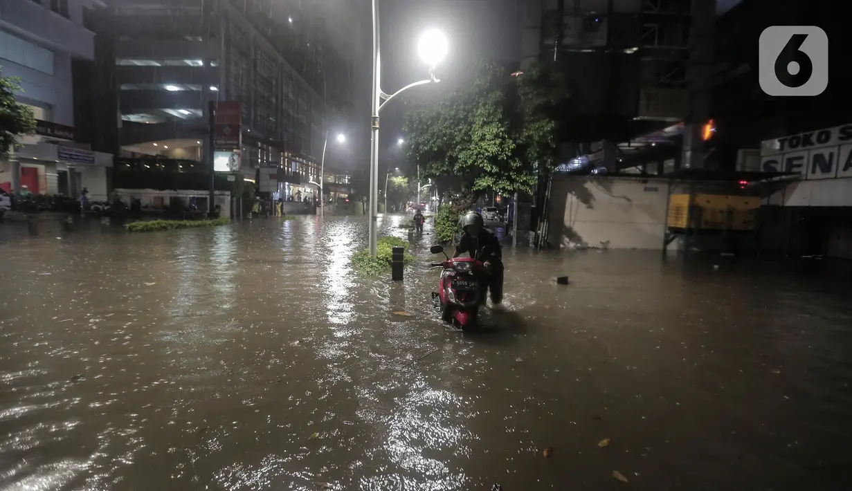 Warga mendorong motor saat terjebak banjir di Jalan Kemang Raya, Jakarta Selatan, Selasa (4/10/2022). Hujan yang mengguyur wilayah Ibu Kota Jakarta mengakibatkan banjir menggenangi kawasan Kemang, Jakarta. (Liputan6.com/Johan Tallo)