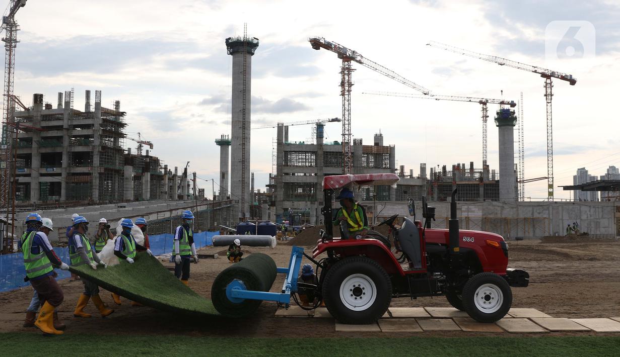 Pekerja melakukan pemasangan rumput di lapangan latih Jakarta International Stadium, Jumat (23/10/2020). Nantinya lapangan latihan ini akan ditumbuhi rumput hybrid, yang memiliki komposisi 5 persen rumput sintetis dan 95 persen natural berjenis Zoysia Matrella. (Liputan6.com/Helmi Fithriansyah)