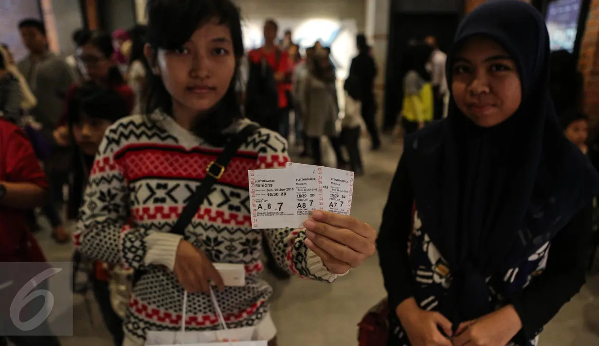Penggemar Minions memperlihatkan tiket nonton bareng Minions yang diselenggarakan oleh CinemaHolic di Blitz Megaplex, Jakarta, Minggu (28/6/2015). (Liputan6.com/Faizal Fanani)