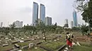 Petugas kebersihan memotong rumput makam di TPU Karet Bivak, Jakarta, Kamis (12/7). Kurang lebih 100 jenazah dimakamkan setiap harinya di wilayah Jakarta. (Merdeka.com/Iqbal Nugroho)