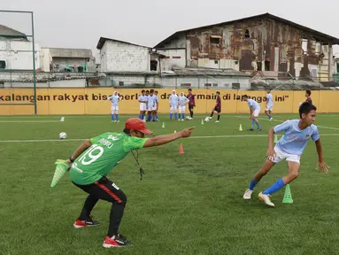 Seorang pelatih memberikan arahan kepada anak asuhnya saat berlatih di Lapangan Ingub Muara Angke, Jakarta Utara. (Bola.com/M Iqbal Ichsan)