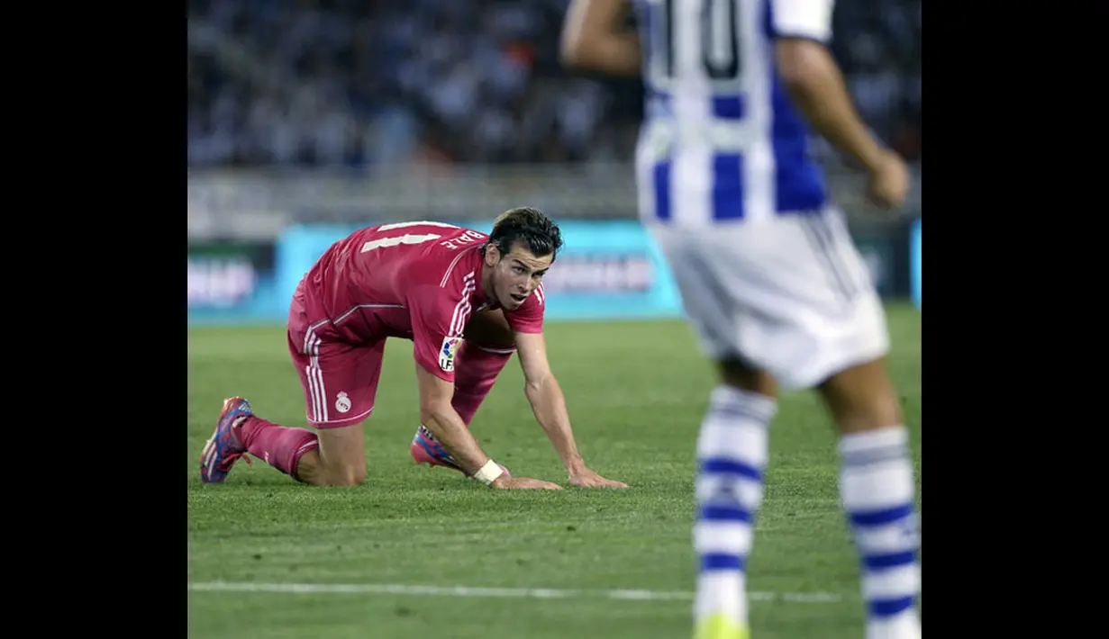 Pemain sayap Real Madrid, Gareth Bale, bangkit setelah jatuh saat berlaga kontra Real Sociedad di lanjutan La Liga 2014-2015 di Stadion Anoeta, (1/9/2014). (REUTERS/Vincent West) 