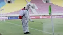 Petugas menyemprot bendera sepak pojok dengan disinfektan sebelum pertandingan antara Persikabo 1973 melawan Arema FC pada laga Piala Menpora di Stadion Manahan, Solo, Minggu (21/3/2021). (Bola.com/M Iqbal Ichsan)