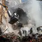 Petugas pemadam kebakaran bekerja setelah sebuah serangan pesawat tak berawak di gedung-gedung di Kyiv, Ukraina, Senin (17/10/2022).  Pesawat tak berawak menghantam sejumlah gedung ibu kota Ukraina pada Senin pagi ledakan tesebut menggema di seluruh Kyiv dan menimbulkan kepanikan sehingga orang-orang berlarian ke lokasi yang aman. (AP Photo/Roman Hrytsyna)