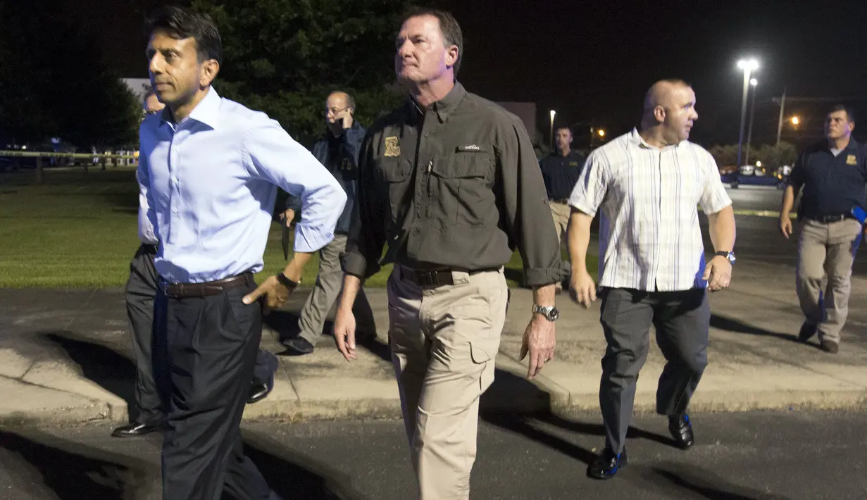 Gubernur Louisiana Bobby Jindal (kiri) saat meninggalkan gedung bioskop Lafayette , Louisiana, AS, Kamis (23/7/ 2015). Kabarnya Penembakan itu terjadi pukul 19.00 waktu setempat di saat mereka menonton film " Train Wreck ". (REUTERS/Lee Celano)