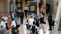 Orang-orang dengan masker berjalan di Grand Central Terminal, New York City, Selasa (27/7/2021). Warga Amerika yang divaksinasi penuh harus kembali memakai masker di dalam ruangan di daerah-daerah di mana virus corona dan terutama varian Delta menyebar dengan cepat. (Spencer Platt/Getty Images/AFP)