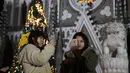 Dua wanita berselfie di depan Gereja Katolik Xishiku saat Malam Natal di Beijing, China (24/12). (AP Photo/Ng Han Guan)