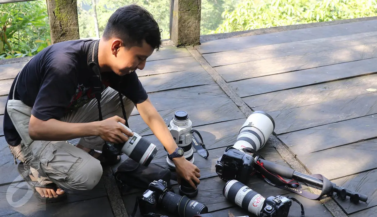 Fotografer menyiapkan alatnya untuk mengabadikan Owa Jawa di Taman Nasional Gunung Pangrango, bohor, Jawa Barat, (24/11). Tim melakukan kegiatan seperti rehabilitasi,restorasi ekosistem dan edukasi bagi masyarakat sekitar. (Liputan6.com/Herman Zakharia)