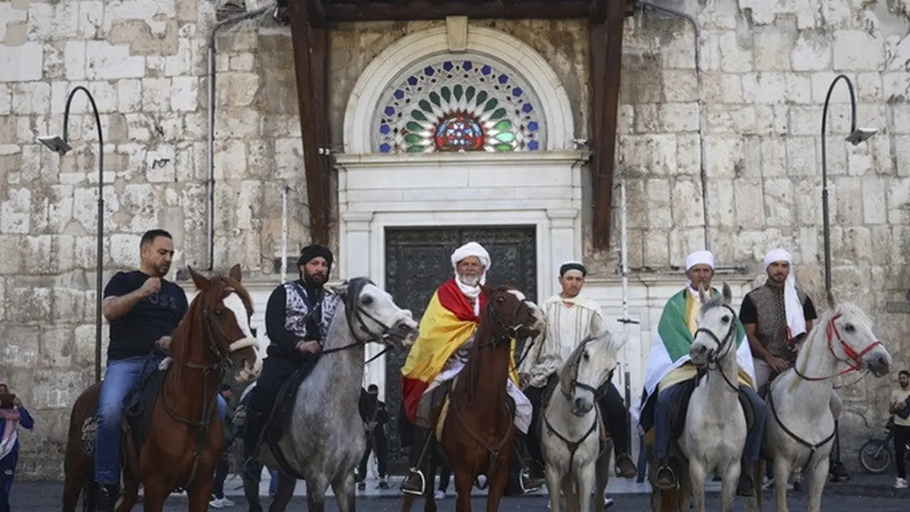Jemaah haji, termasuk tiga orang dari Spanyol, berpose dengan kuda mereka di luar Pasar Souq al-Hamidiyah di Damaskus, Suriah, 21 April 2025, selama perjalanan berkuda selama berbulan-bulan dari Spanyol ke Arab Saudi untuk melaksanakan ibadah haji.